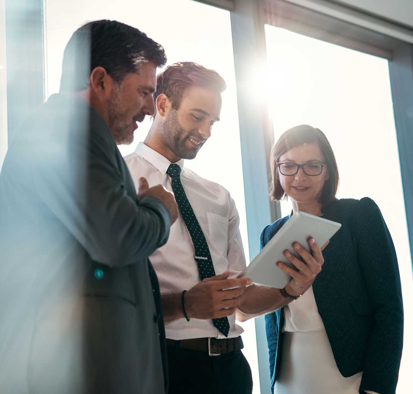 Three Executives Looking at a Tablet
